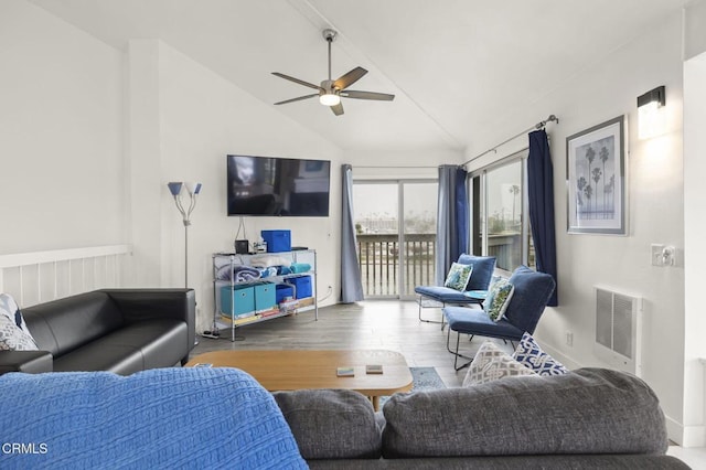 living room with vaulted ceiling, heating unit, wood finished floors, and ceiling fan
