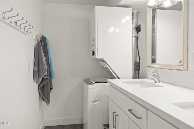 bathroom featuring double vanity, baseboards, and a sink