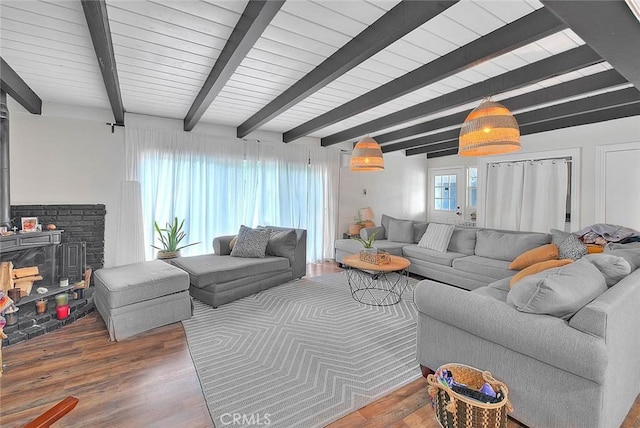 1027 W Durness St, West Covina, CA 91790 - living room with a wood stove, beamed ceiling, and wood finished floors