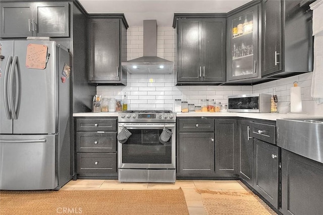 1027 W Durness St, West Covina, CA 91790 - kitchen with appliances with stainless steel finishes, wall chimney range hood, light countertops, and tasteful backsplash