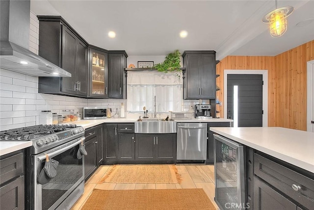 1027 W Durness St, West Covina, CA 91790 - kitchen featuring wall chimney range hood, appliances with stainless steel finishes, wine cooler, a sink, and tasteful backsplash