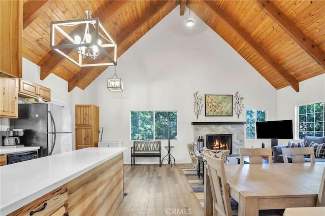 272 Fairway Dr, Lake Arrowhead, CA 92352 - kitchen with a chandelier, freestanding refrigerator, high vaulted ceiling, a lit fireplace, and light wood-type flooring