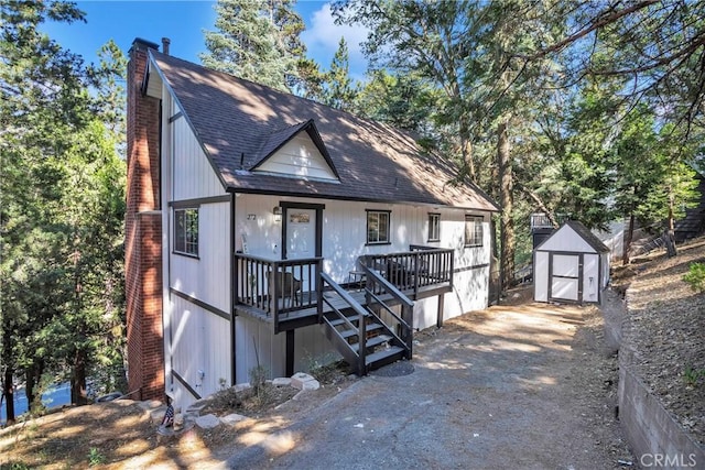 272 Fairway Dr, Lake Arrowhead, CA 92352 - view of front of property with a storage shed, a chimney, roof with shingles, and a porch