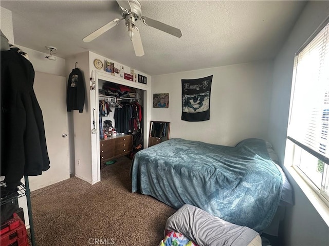 carpeted bedroom with a closet, a textured ceiling, and ceiling fan