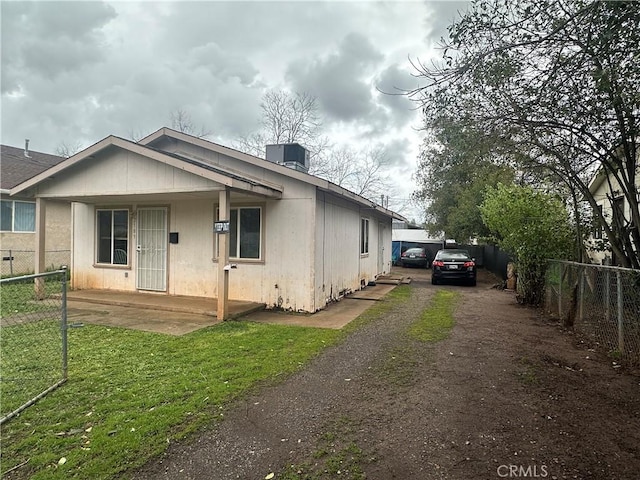 view of front of home featuring central air condition unit, a front yard, driveway, and fence