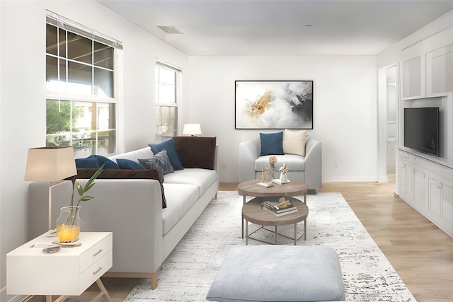 living area featuring visible vents, light wood-type flooring, and baseboards