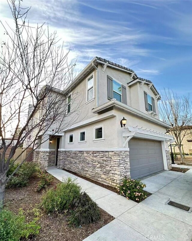 1437 Girona Dr, Pomona, CA 91766 - view of property exterior with stone siding, stucco siding, a garage, and driveway