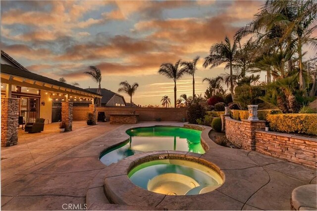 view of pool with a pool with connected hot tub and a patio area