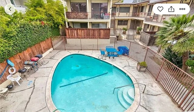 community pool featuring a patio and fence
