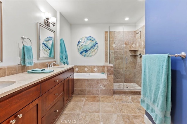 full bath with a sink, a shower stall, double vanity, stone finish floor, and a garden tub