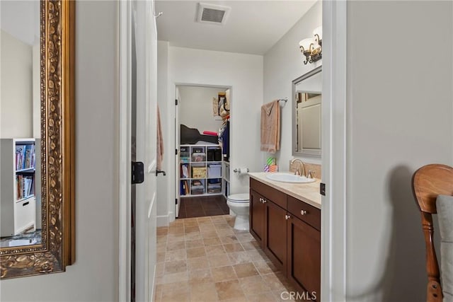 bathroom with toilet, tile patterned flooring, visible vents, and vanity