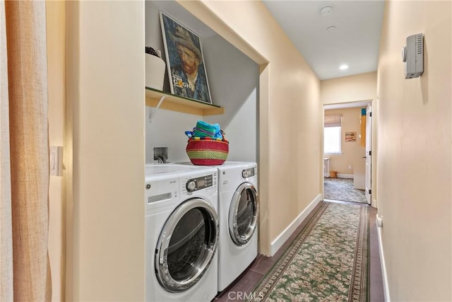 washroom featuring baseboards, dark tile patterned flooring, laundry area, and washing machine and dryer