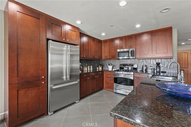 kitchen with recessed lighting, decorative backsplash, light tile patterned floors, appliances with stainless steel finishes, and a sink