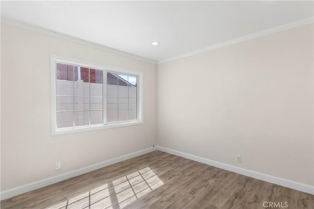 empty room featuring crown molding, wood finished floors, baseboards, and recessed lighting