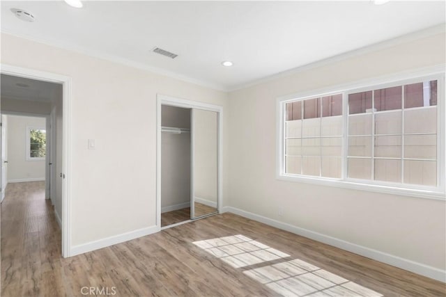 unfurnished bedroom with crown molding, wood finished floors, and baseboards