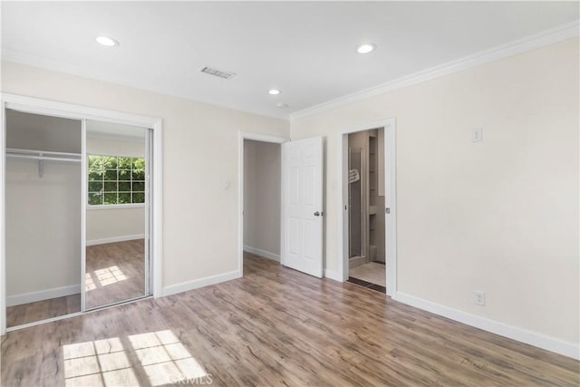 unfurnished bedroom featuring crown molding, visible vents, baseboards, and a closet