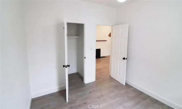 unfurnished bedroom with a closet, baseboards, and wood finished floors