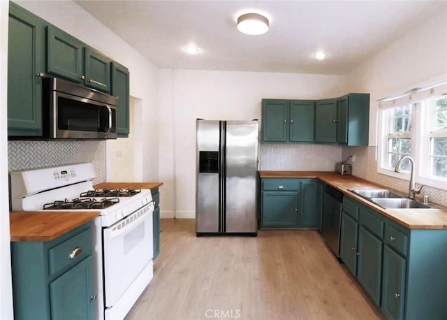 kitchen featuring a sink, wooden counters, green cabinetry, and stainless steel appliances