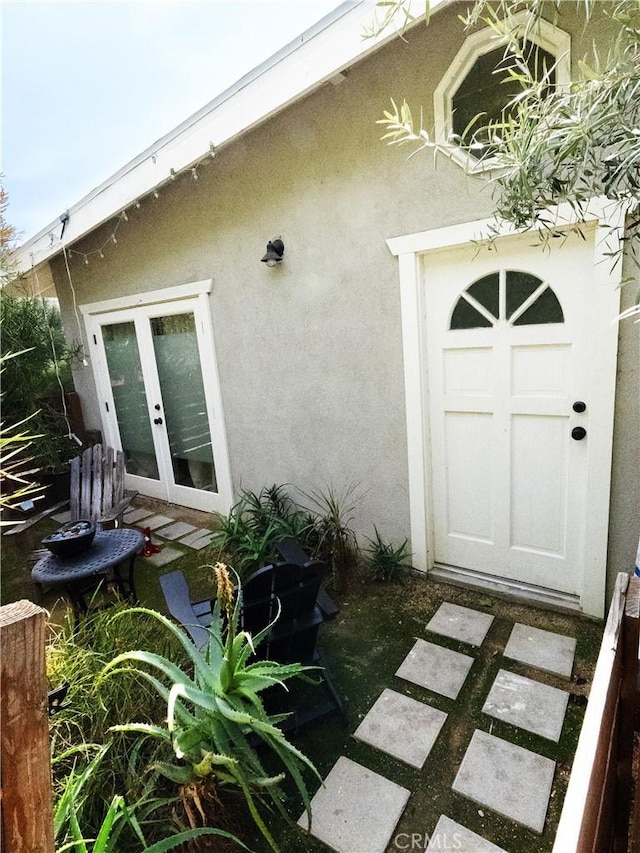 entrance to property with french doors and stucco siding