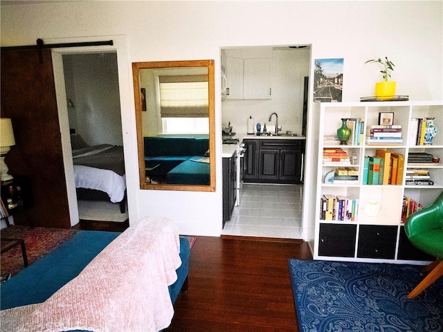 bedroom with a sink, connected bathroom, and wood finished floors