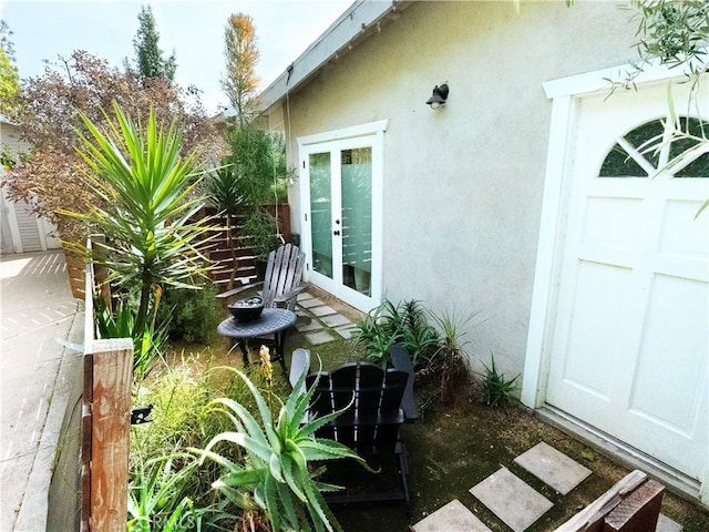 view of home's exterior with stucco siding and french doors