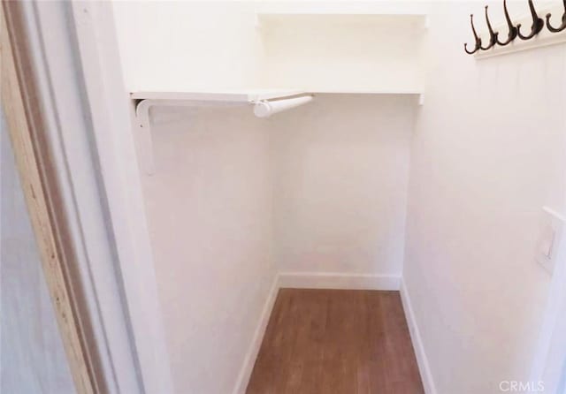 walk in closet with wood finished floors