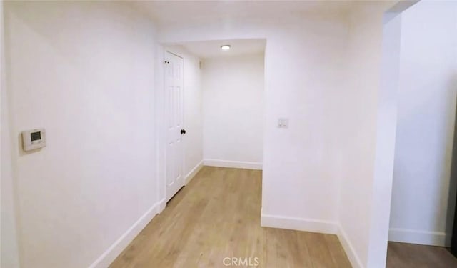hallway with light wood-style flooring and baseboards