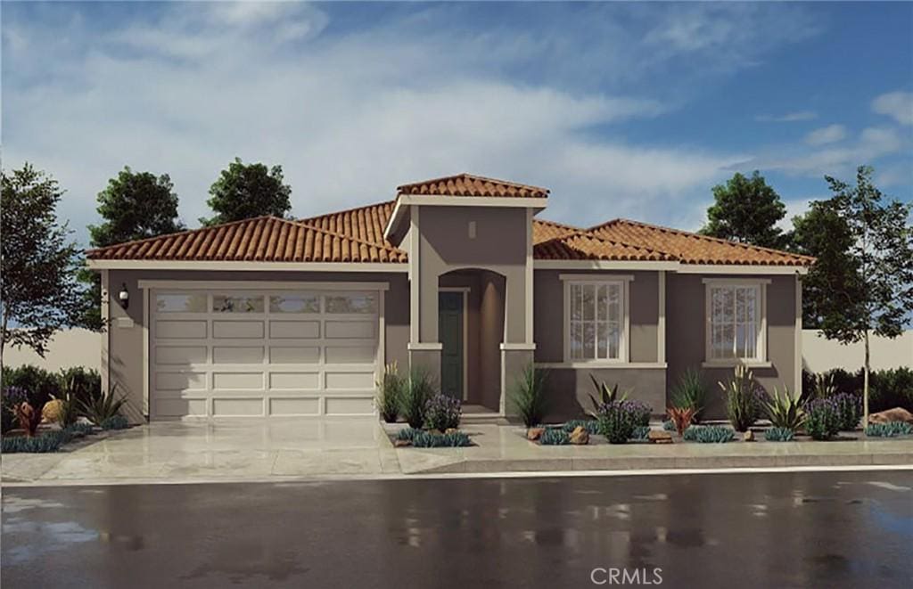 mediterranean / spanish-style house with stucco siding, driveway, an attached garage, and a tile roof