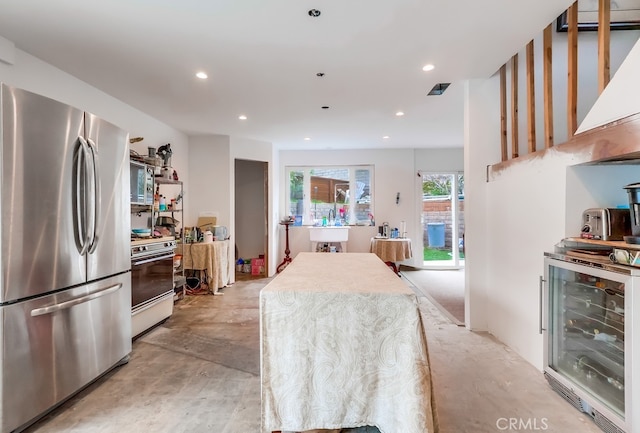 kitchen featuring wine cooler, concrete flooring, recessed lighting, appliances with stainless steel finishes, and a sink