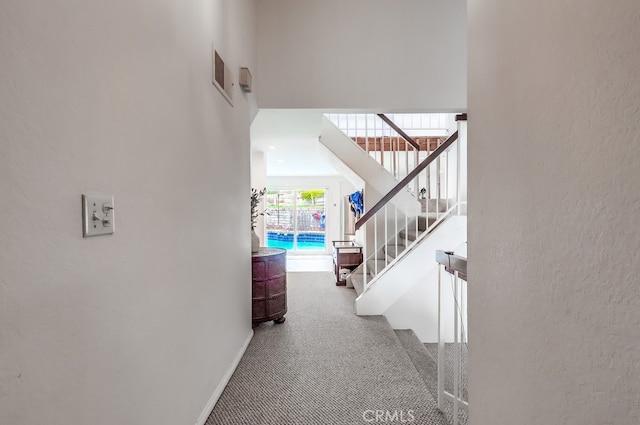hall featuring baseboards, carpet floors, and stairs