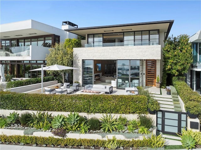 2914 Ocean Blvd, Corona Del Mar, CA 92625 - rear view of property with stone siding, stairway, an outdoor living space with a fire pit, a balcony, and a patio area