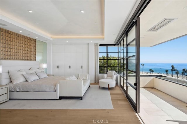 2914 Ocean Blvd, Corona Del Mar, CA 92625 - bedroom with light wood-type flooring, a tray ceiling, a water view, and recessed lighting