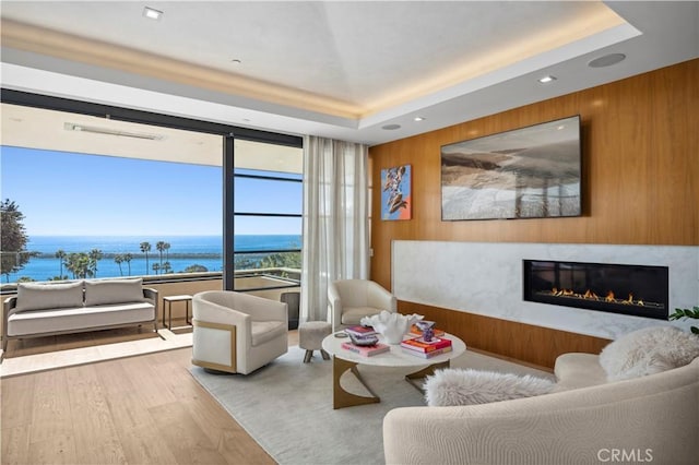 2914 Ocean Blvd, Corona Del Mar, CA 92625 - living area with a glass covered fireplace, a tray ceiling, a water view, and wood finished floors