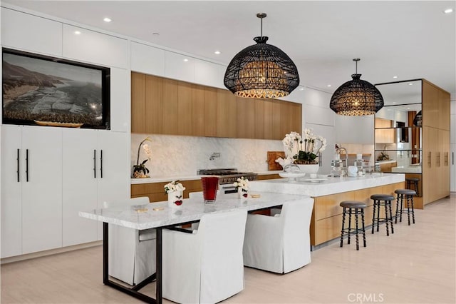 2914 Ocean Blvd, Corona Del Mar, CA 92625 - kitchen with a breakfast bar area, hanging light fixtures, high end stainless steel range, modern cabinets, and a chandelier