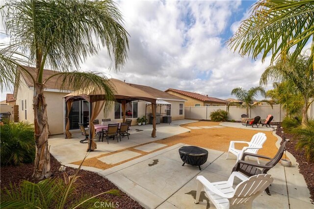 29068 Aubrey Cir, Winchester, CA 92596 - back of house with an outdoor fire pit, a fenced backyard, a gazebo, stucco siding, and a patio area