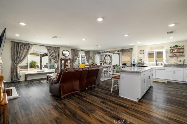 29068 Aubrey Cir, Winchester, CA 92596 - kitchen with white cabinets, visible vents, a kitchen island, dark wood-type flooring, and open floor plan