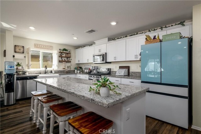 29068 Aubrey Cir, Winchester, CA 92596 - kitchen with a center island, dark wood finished floors, stainless steel appliances, visible vents, and white cabinets