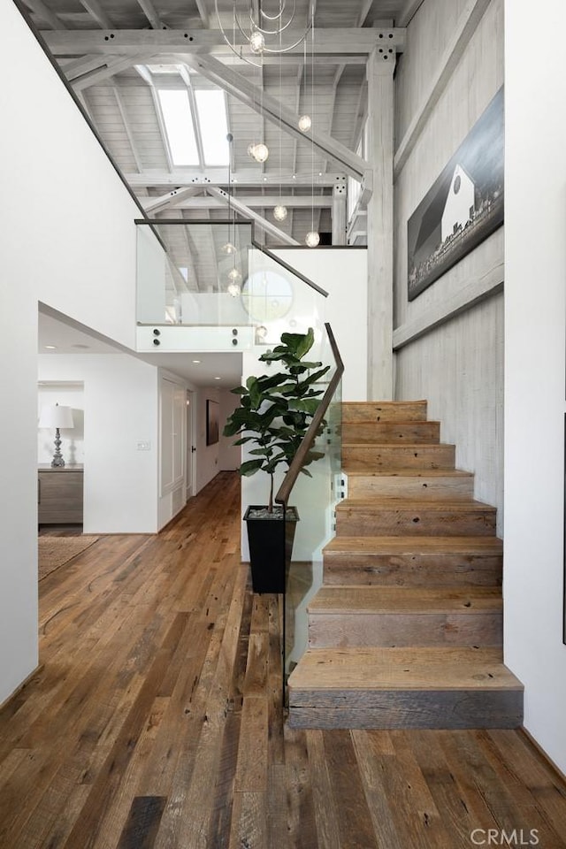604 Begonia Ave, Corona Del Mar, CA 92625 - stairs featuring a high ceiling, hardwood / wood-style flooring, and a notable chandelier