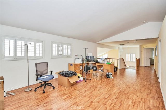 office with lofted ceiling, light wood-style flooring, and baseboards