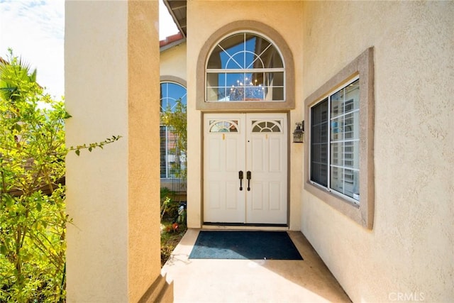 doorway to property featuring stucco siding