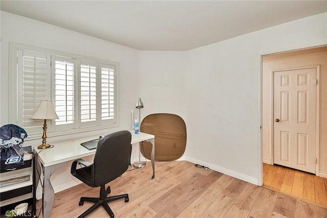 home office featuring baseboards and light wood-type flooring