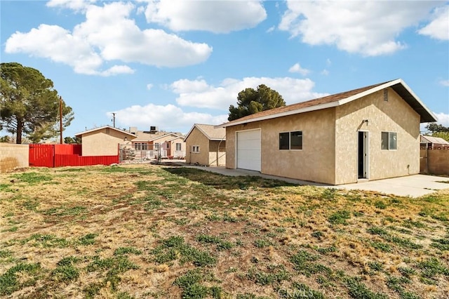 1202 W Lancaster Blvd, Lancaster, CA 93534 - rear view of property featuring stucco siding, a garage, and a patio area