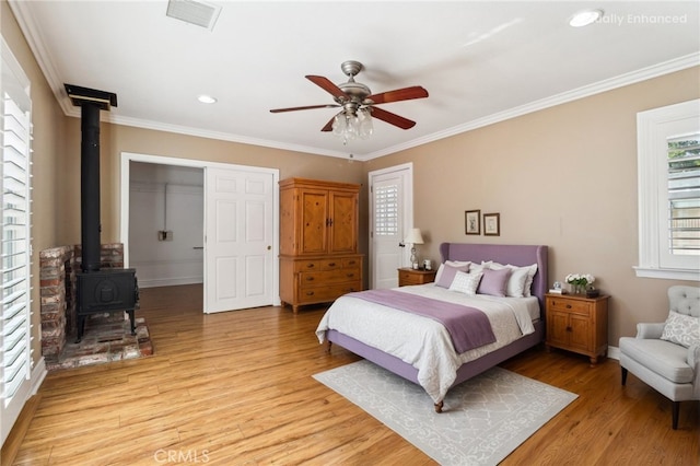 1202 W Lancaster Blvd, Lancaster, CA 93534 - bedroom with a wood stove, light wood-style floors, crown molding, baseboards, and recessed lighting