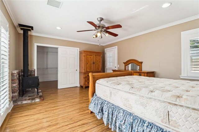 1202 W Lancaster Blvd, Lancaster, CA 93534 - bedroom featuring light wood-style floors, a wood stove, ornamental molding, a ceiling fan, and recessed lighting