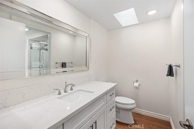 647 Avenida Sevilla Unit A, Laguna Woods, CA 92637 - full bathroom with toilet, vanity, wood finished floors, a skylight, and a shower with door
