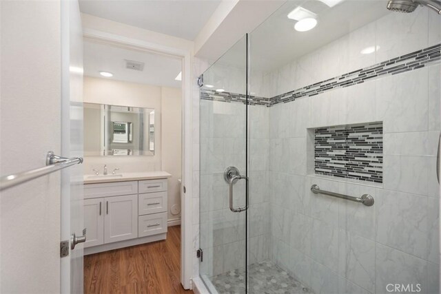647 Avenida Sevilla Unit A, Laguna Woods, CA 92637 - bathroom featuring a stall shower, wood finished floors, vanity, and visible vents
