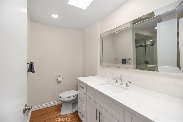 647 Avenida Sevilla Unit A, Laguna Woods, CA 92637 - full bathroom with baseboards, toilet, an enclosed shower, vanity, and wood finished floors