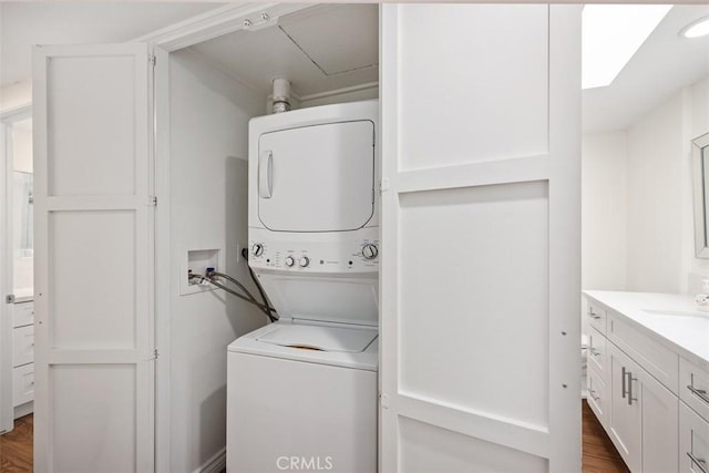 647 Avenida Sevilla Unit A, Laguna Woods, CA 92637 - clothes washing area featuring dark wood-style flooring, stacked washer / dryer, laundry area, and a sink