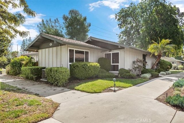 647 Avenida Sevilla Unit A, Laguna Woods, CA 92637 - view of front of house with board and batten siding and a front lawn