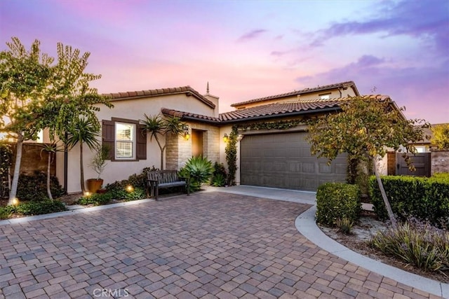 35 Cantar St, Rancho Mission Viejo, CA 92694 - mediterranean / spanish-style home featuring an attached garage, a tile roof, stone siding, stucco siding, and decorative driveway